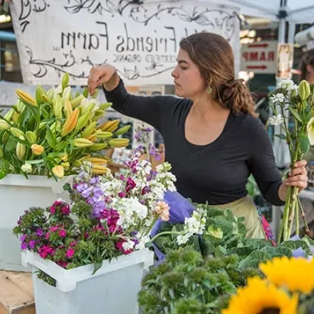 A vendor selling fresh-cut flowers at a farmer's market in downtown Northampton.